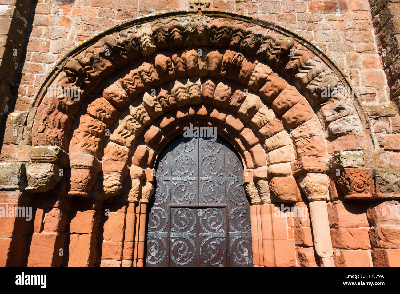 Beeindruckende normannische Torbogen am Westportal zu St Bienen Klosterkirche in Cumbria, Großbritannien, um 1140 erbaut Stockfoto