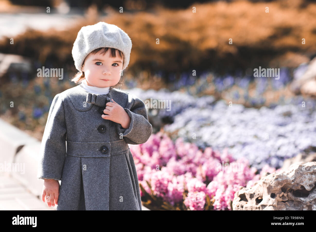Cute Baby Mädchen 1-2 Jahre alten tragen Jacke und Baskenmütze im Park. Mit  Blick auf die Kamera. Kindheit Stockfotografie - Alamy