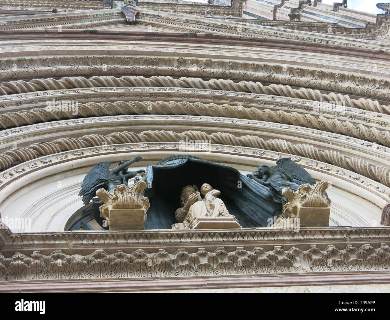 Nahaufnahme der Figurengruppe und kunstvollen Steinmetzarbeiten Bögen an der Fassade der Dom von Orvieto Stockfoto