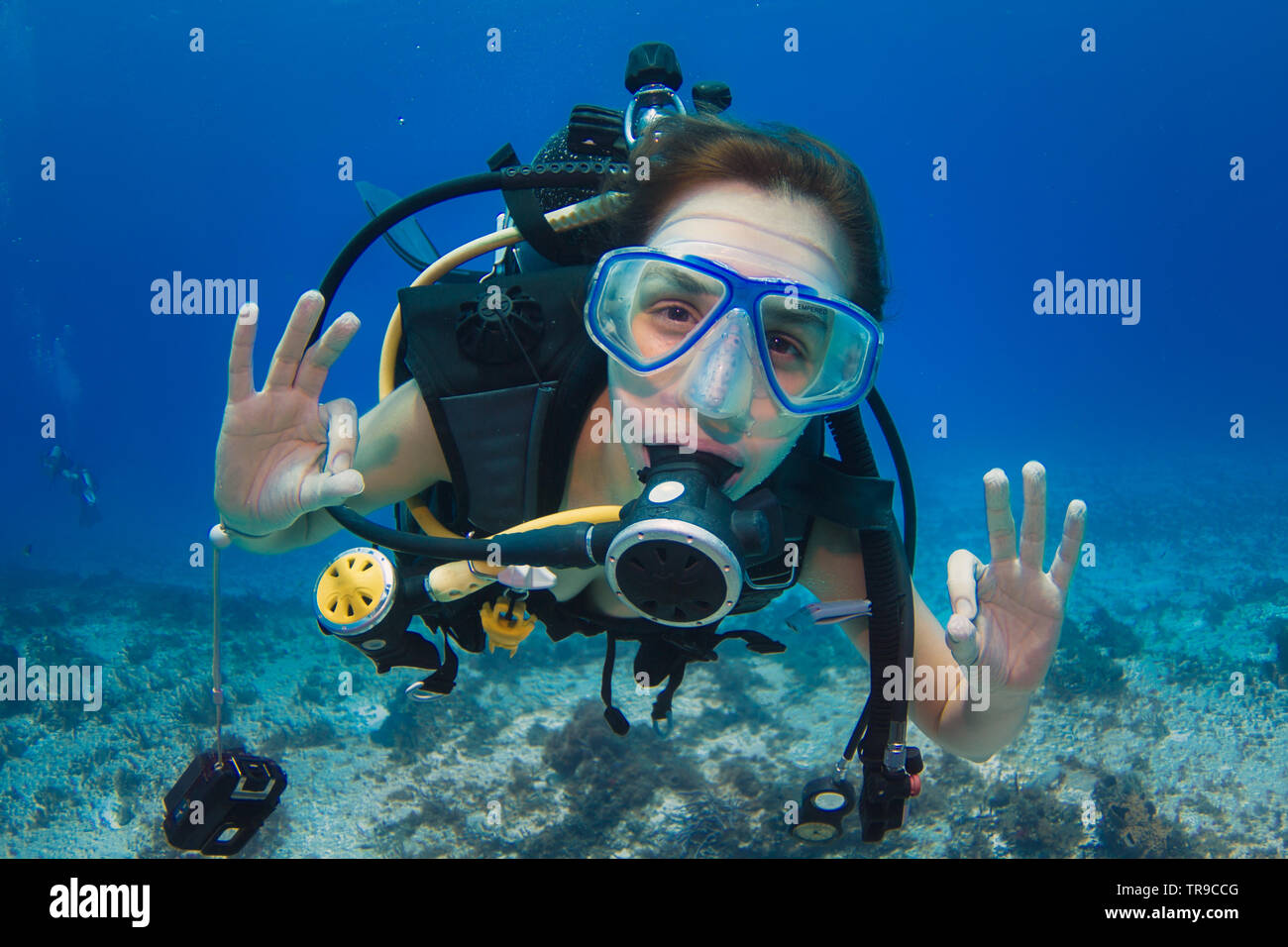 COZUMEL, MEXIKO: rothaarige Frau, Scuba Diver, ok Zeichen unter Wasser mit beiden Händen, mit einem blauen Maske Stockfoto