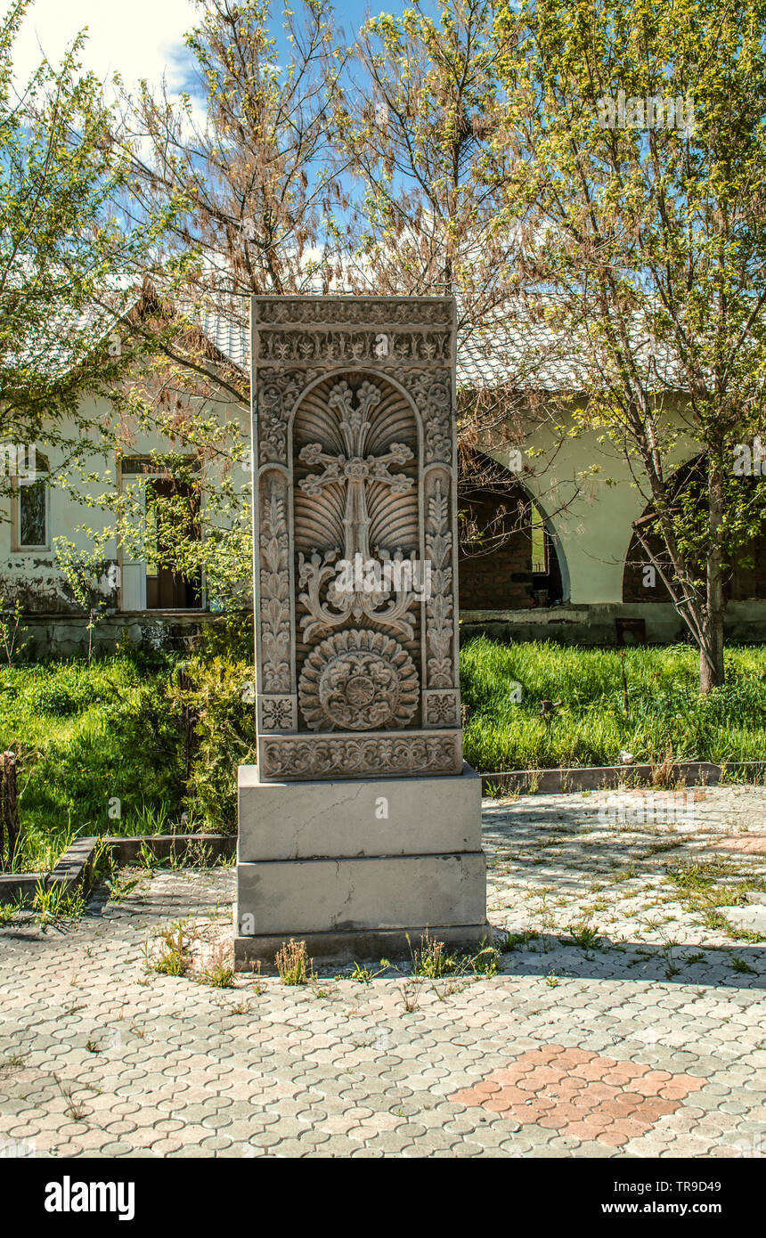 Khachkar aus grauem Stein mit ethnischen Mustern im Innenhof der Kirche der Heiligen Märtyrer im Dorf Teghenik in Armenien Stockfoto