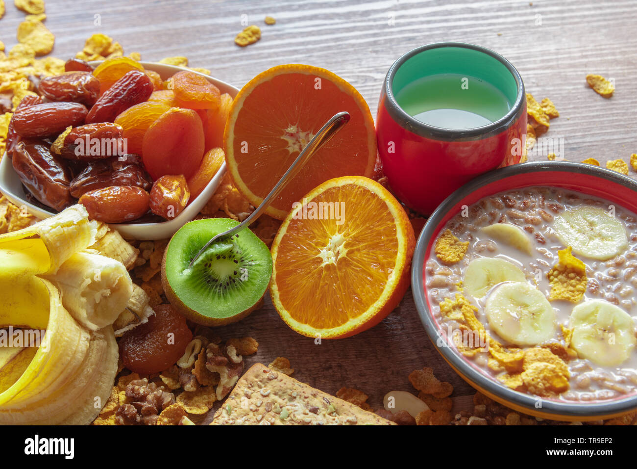 Gesundes Frühstück Schüssel, getrocknete Pflaumen, Datteln, Milch mit Müsli und Banane und Kiwi in den frühen Morgenstunden Stockfoto