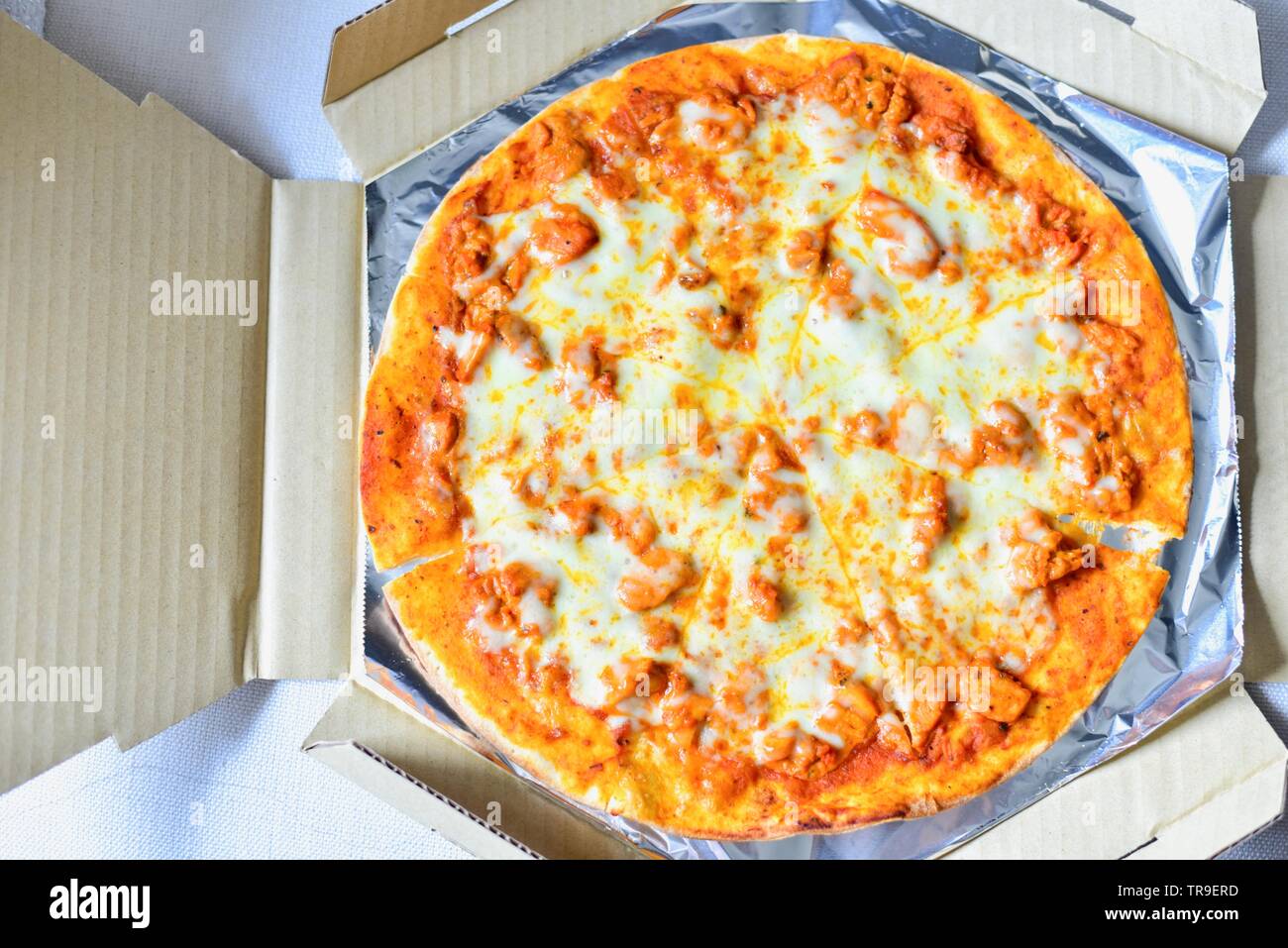 Blick von oben auf die Indian-Style Butter Chicken Pizza mit Mozzarella Käse Stockfoto