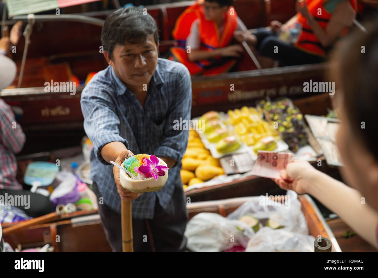 Der Anbieter dem Kunden eine Kokosnuss Schale bei Damnoen Saduak Markt, Damnoen Saduak Bezirk, Provinz Ratchaburi, in der Nähe von Bangkok, Thailand, Asien Stockfoto