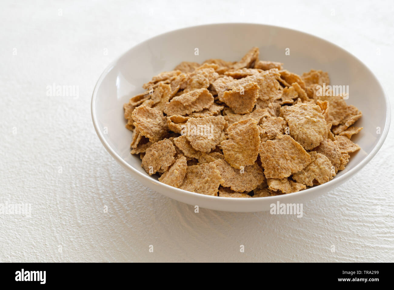 Schüssel gerösteten Haferflocken Flocken in weißen Hintergrund leckere, gesunde Frühstück, gute Quelle für Ballaststoffe und Vitamine Stockfoto