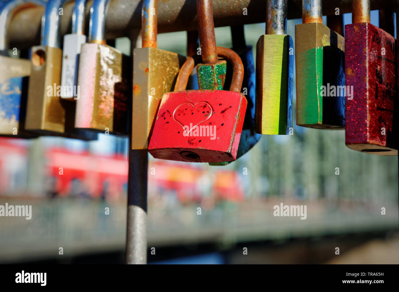 Liebe Vorhängeschlösser an einer Brücke in Köln, im unscharfen Hintergrund Ein Zug über die Brücke ist Stockfoto