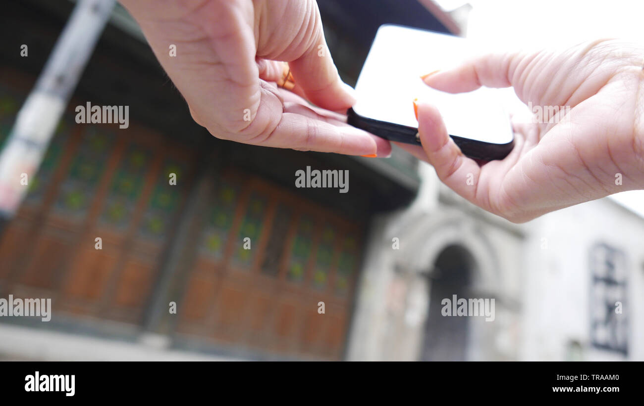 Hand, schwarz Telefon suchen Informationen zu unscharfen Hintergrund, Low Angle selektiven Fokus Stockfoto