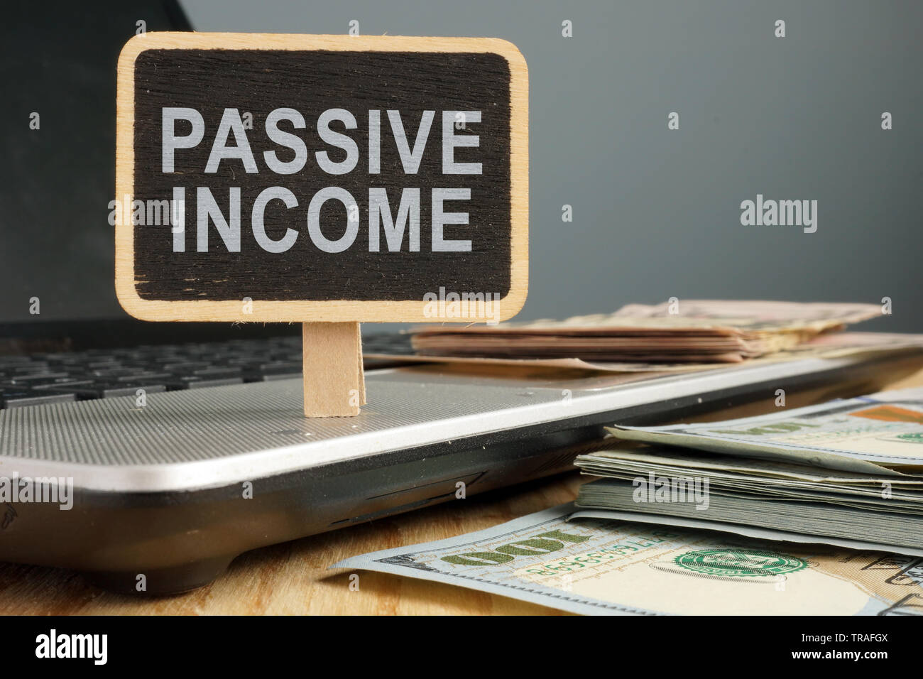 Passives Einkommen Konzept. Notebook und Stapel von Bargeld. Stockfoto
