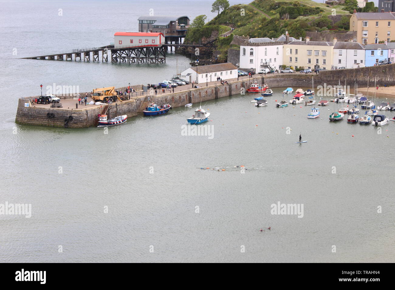 Ein Foto von Tenby Hafen, Pembrokeshire, Wales, UK. Boote, Häuser, Menschen genießen die Bank Holiday sonnige Wetter. Stockfoto