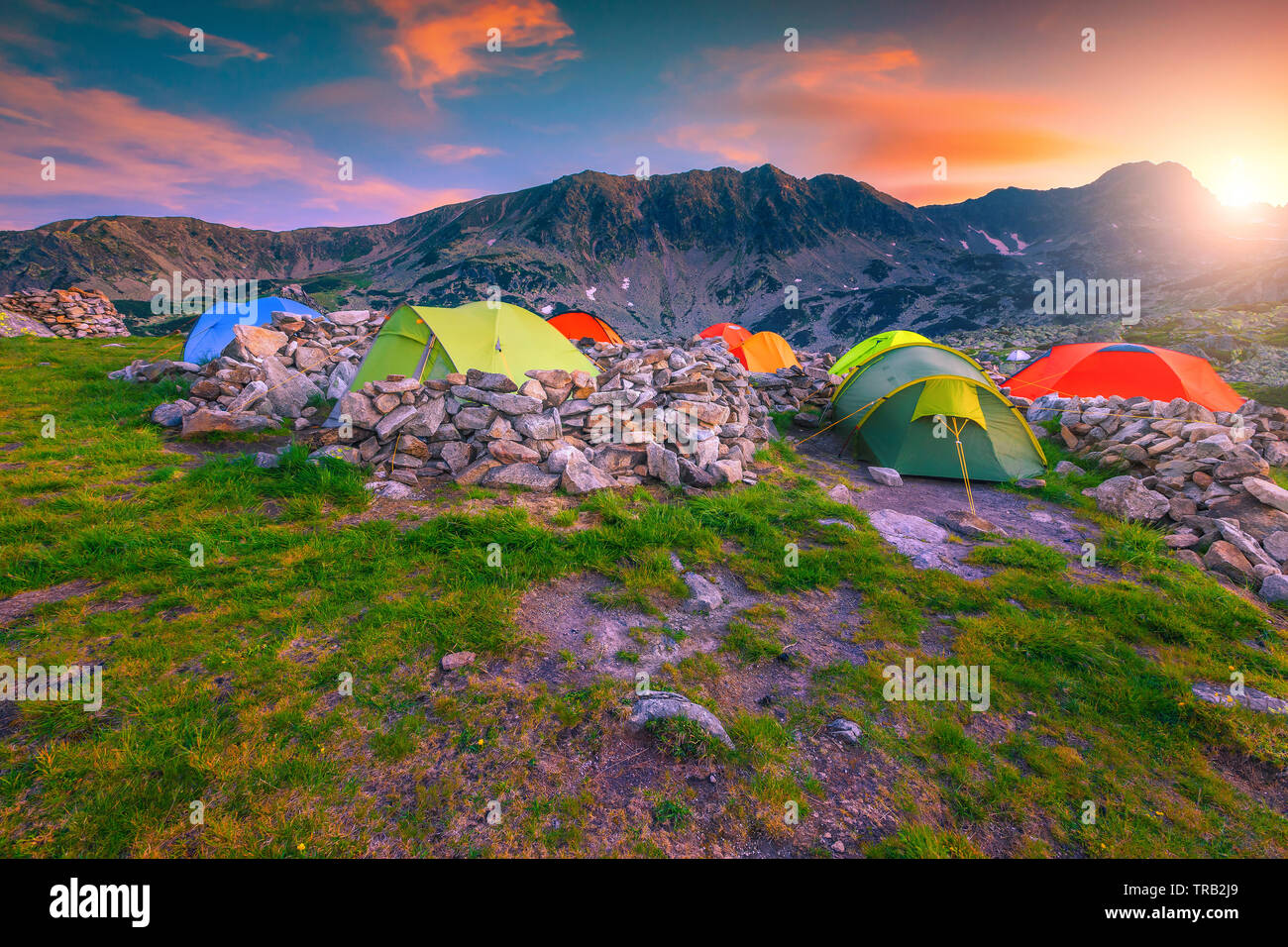 Beliebte Berg wild Camping, spektakuläre Camp mit bunten Zelte. Atemberaubenden Sonnenuntergang in den Bergen mit Campground, Retezat-gebirge, Transylvani Stockfoto