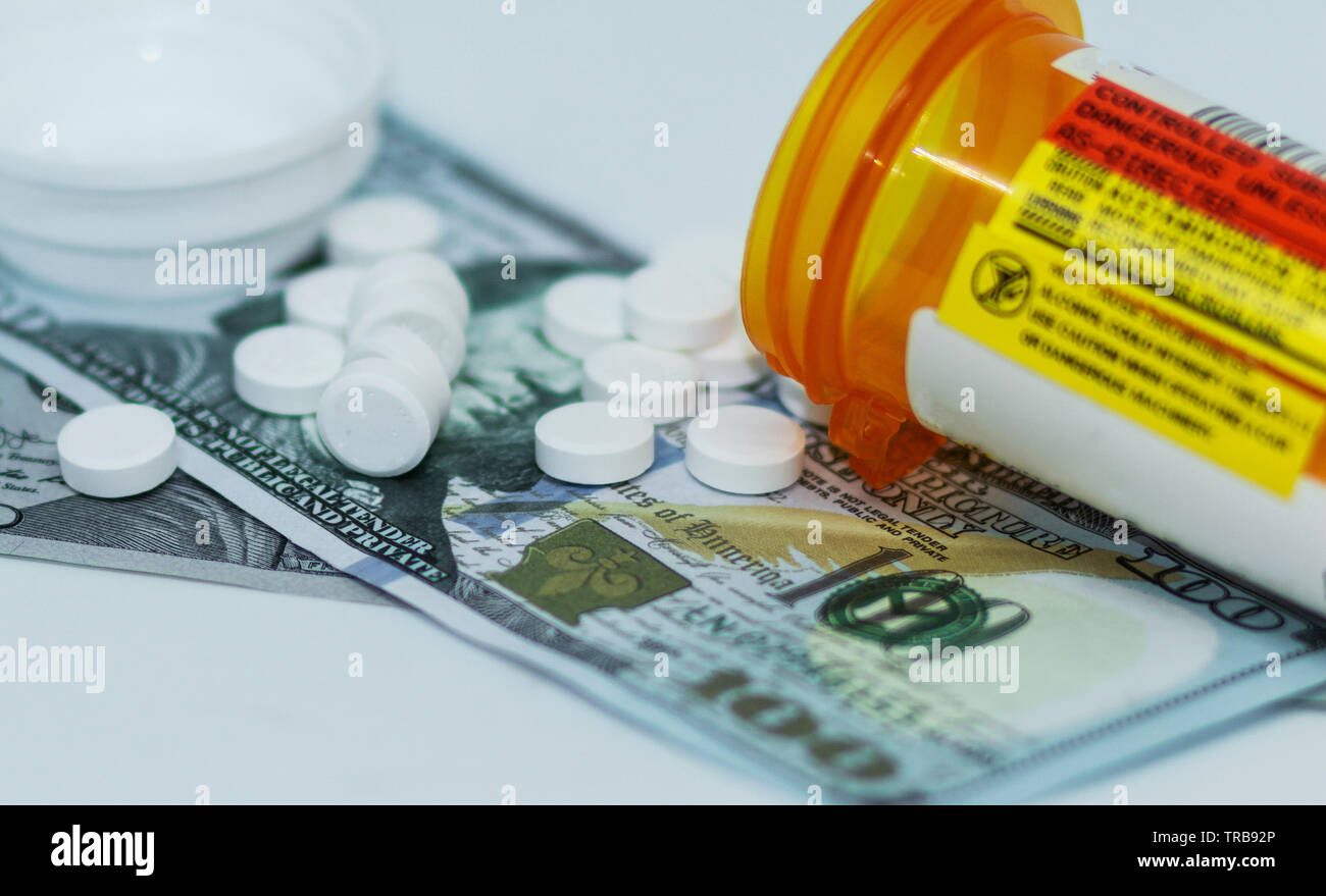 Verschreibungspflichtige Medikamente Auslaufen Ihrer Container, an der Oberseite von einem Hundert-euro-Scheine. Stockfoto
