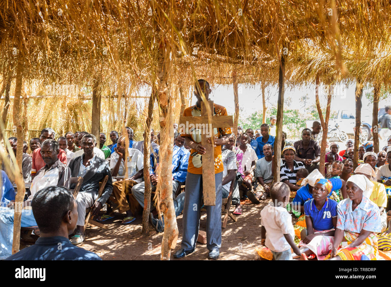 Malawische Pastor hält ein Kreuz in der Mitte seines Dorfes Kirche aus Gras in Nsanje Malawi Stockfoto