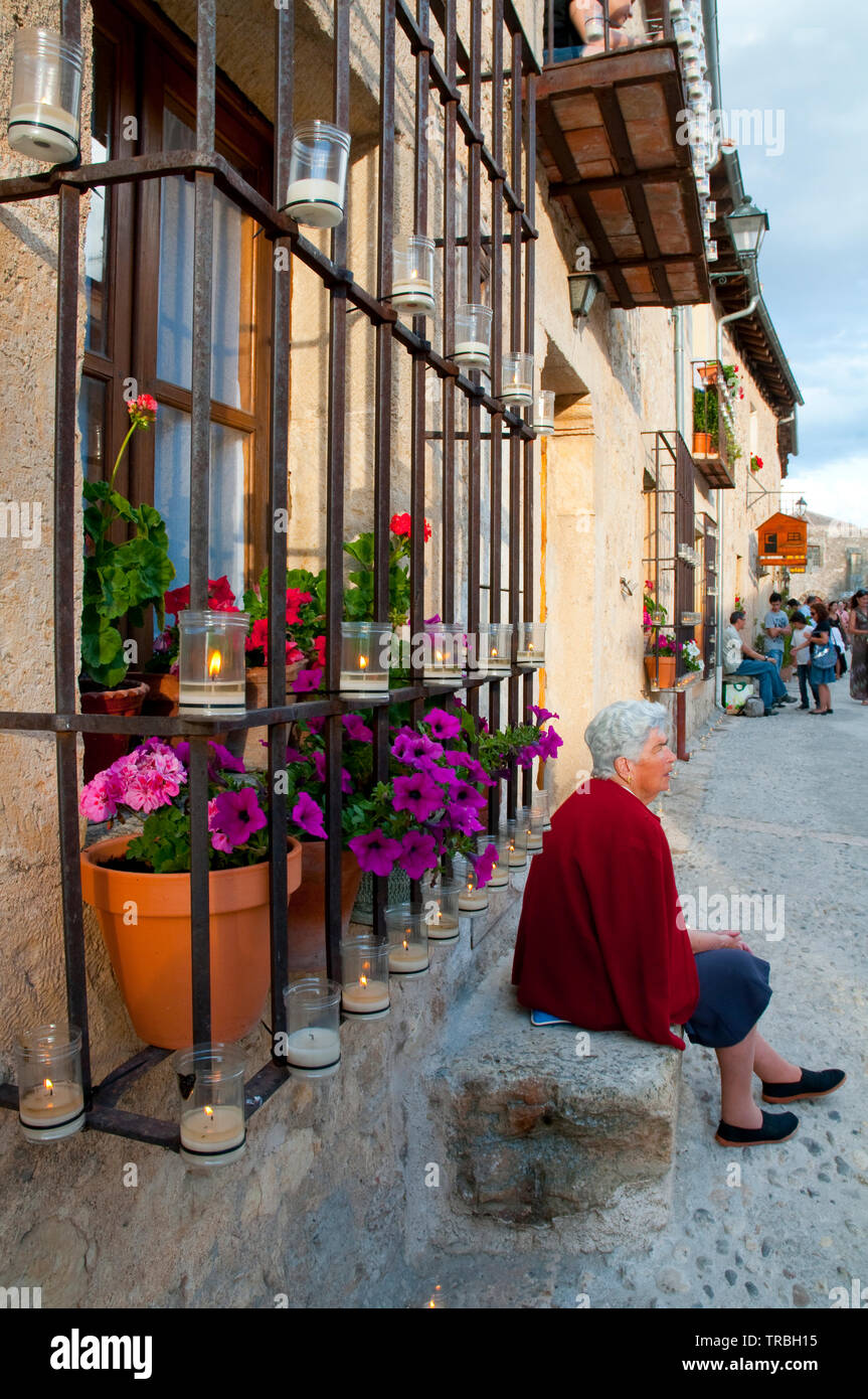 Alte Frau sitzt durch Ihr Haus vor dem Concierto de Las Velas. Pedraza, Segovia Provinz Castilla León, Spanien. Stockfoto