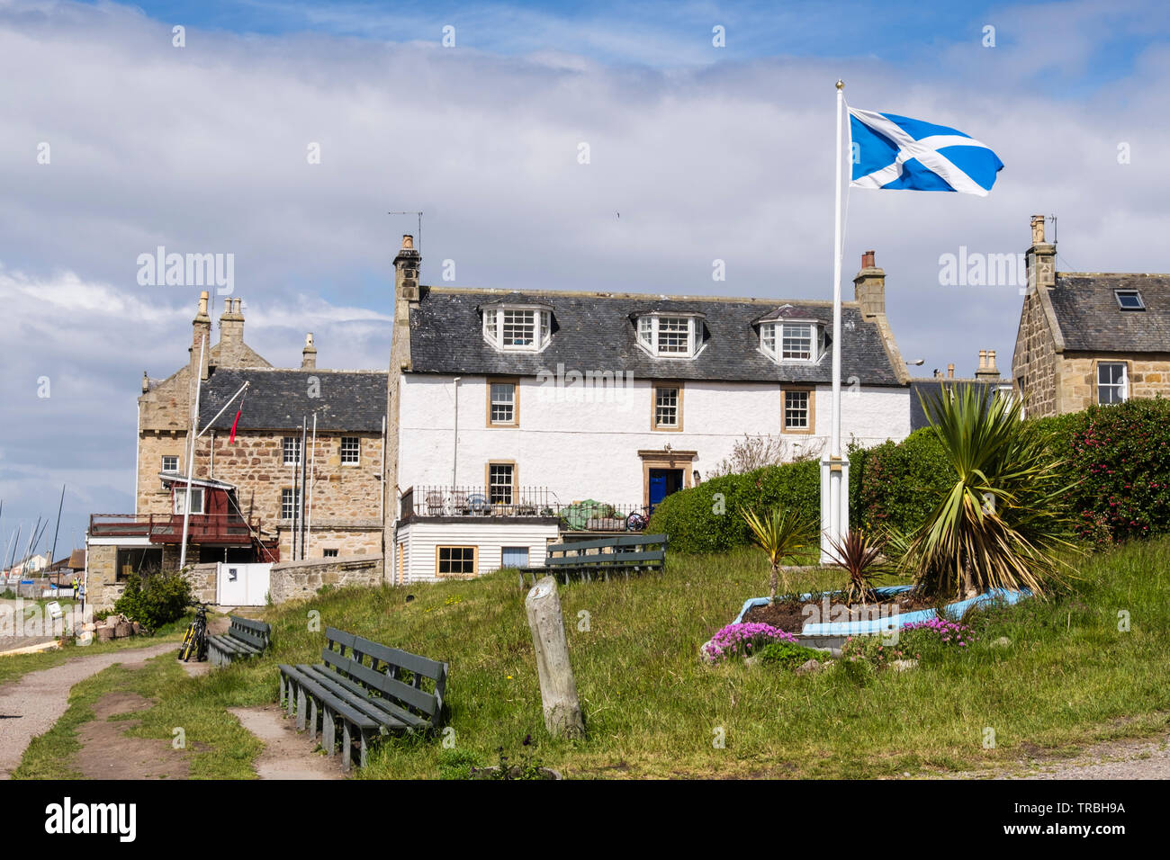 Schottische Flagge außerhalb der alten Gebäude im Dorf an der Küste von Findhorn, Moray, Schottland, Großbritannien, Großbritannien Stockfoto