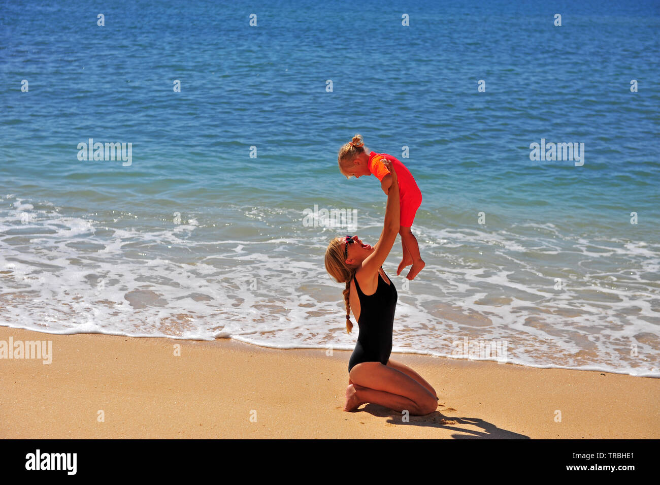 Junge Mutter mit ihrem kleinen Mädchen Spaß am Strand. Stockfoto