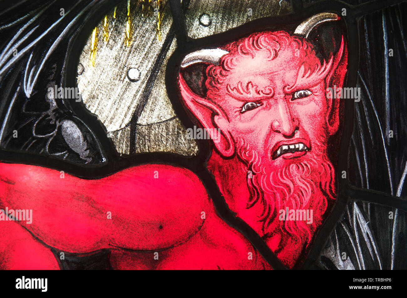 Portrait als Vertreter der Teufel, in der Glasmalerei. Detail eines Fensters in Saint Andrew's Church im Dorset Dorf West Stafford. England. UK. Stockfoto