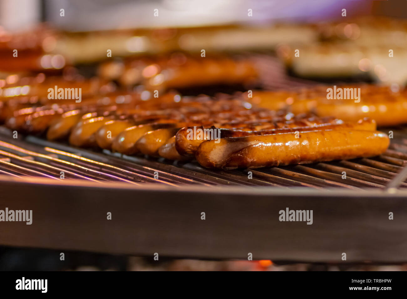 Prozess der kochen Hotdogs an der Street Food Festival. Kochen im Freien service Gastronomie und Essen zum Mitnehmen Konzept Stockfoto