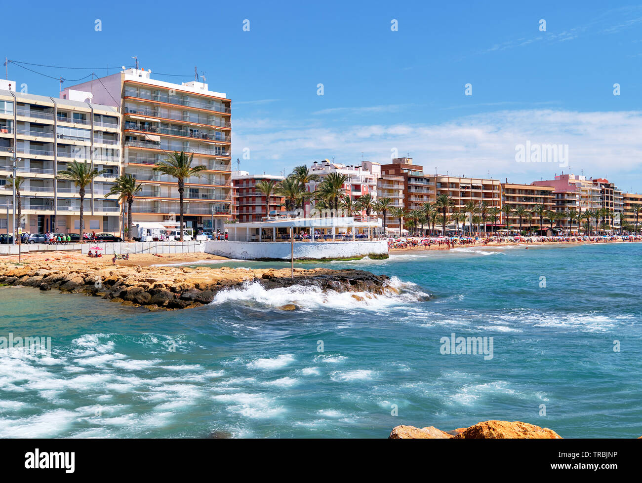 Blick auf den Strand Playa del Cura, urbane Skyline typisches Hochhaus beherbergt ein küstennahes Restaurantgebäude, eine von Palmen gesäumte Promenade, Spanien Stockfoto