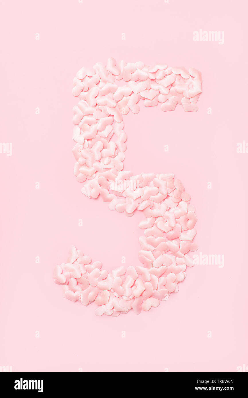 Nummer fünf aus dekorativen rosa Herzen gesammelt. Auf rosa Hintergrund isoliert Stockfoto