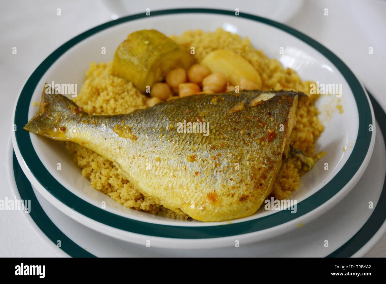 Ein traditioneller Nordafrikanischer Schüssel Couscous mit Fisch (Goldbrasse), Kichererbsen und Gemüse, serviert in einem Restaurant in der Medina von Tunis, Tunesien. Stockfoto