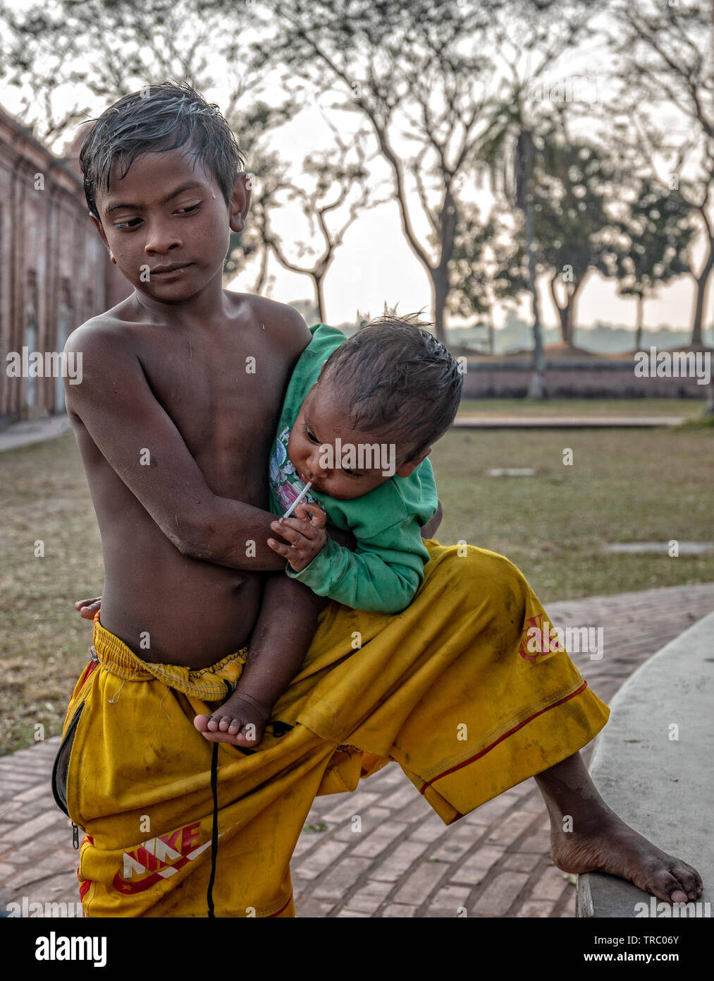 Kleiner Junge, der seinen kleinen Bruder in der Shait Gumbad Moschee in Bangladesch babysitting Stockfoto