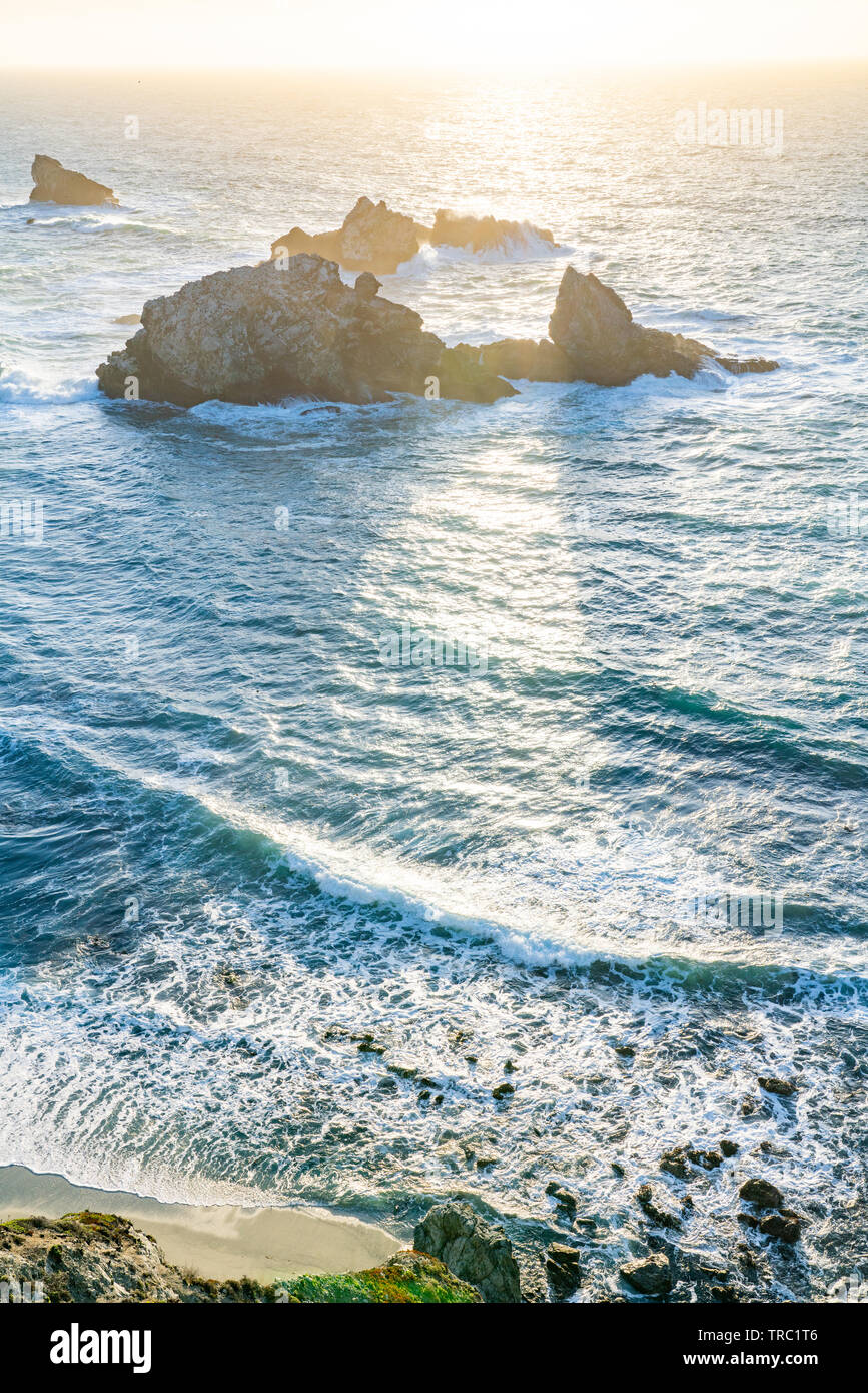 Die untergehende Sonne erzeugt Schatten hinter Meer Stapel entlang einer wunderschönen Küste, Big Sur, Kalifornien, USA. Stockfoto