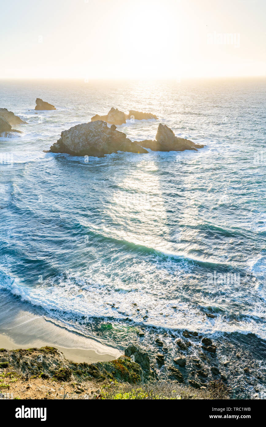 Die untergehende Sonne erzeugt Schatten hinter Meer Stapel entlang einer wunderschönen Küste, Big Sur, Kalifornien, USA. Stockfoto
