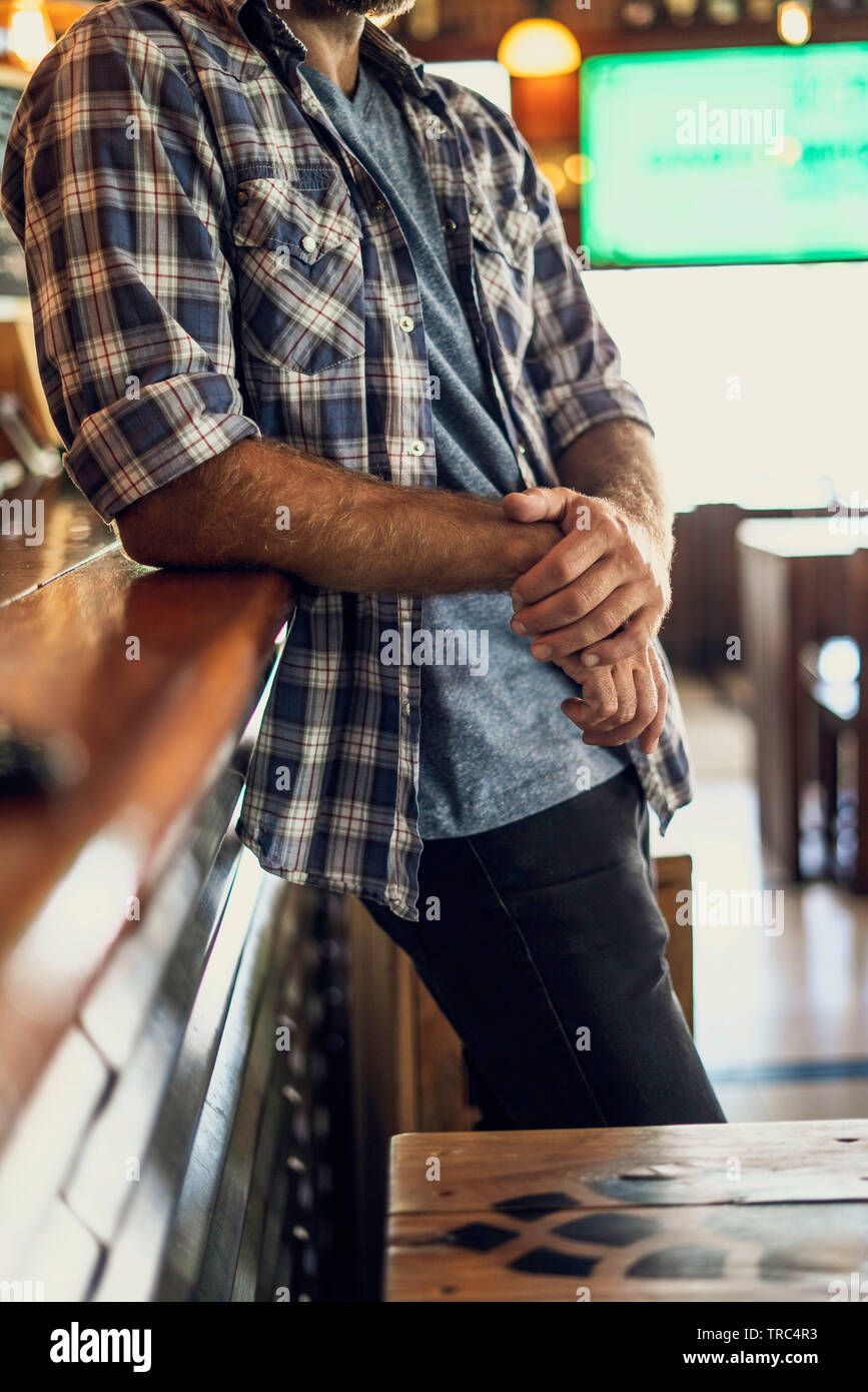 Mann lehnte sich gegen bar Stockfoto