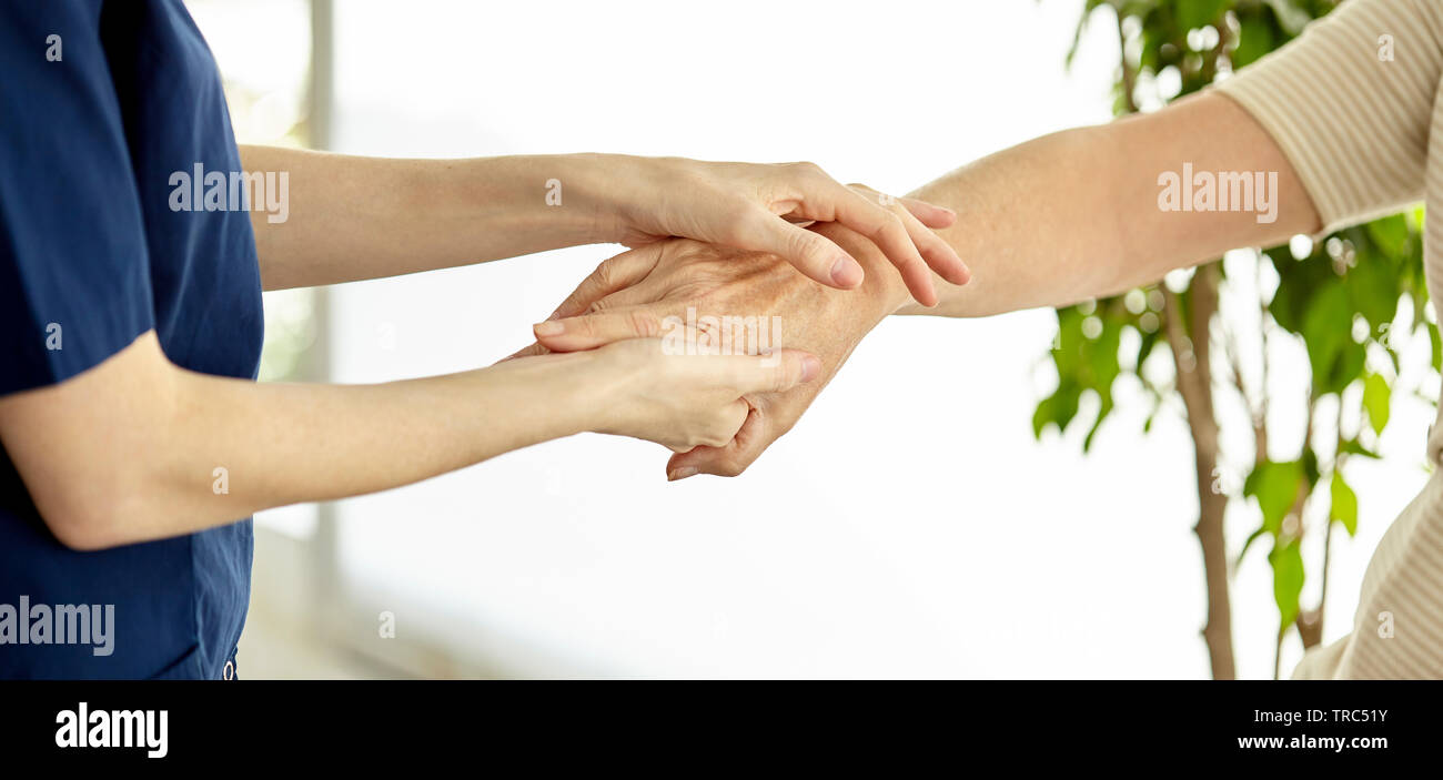 Krankenschwester Hand halten Patienten Stockfoto
