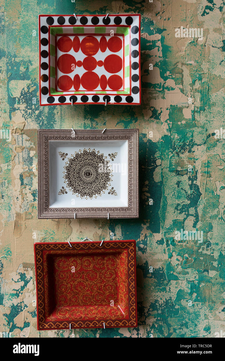 Detail der keramischen Platten mit dem Nahen Osten Design auf Wand mit abblätternder Farbe. Stockfoto