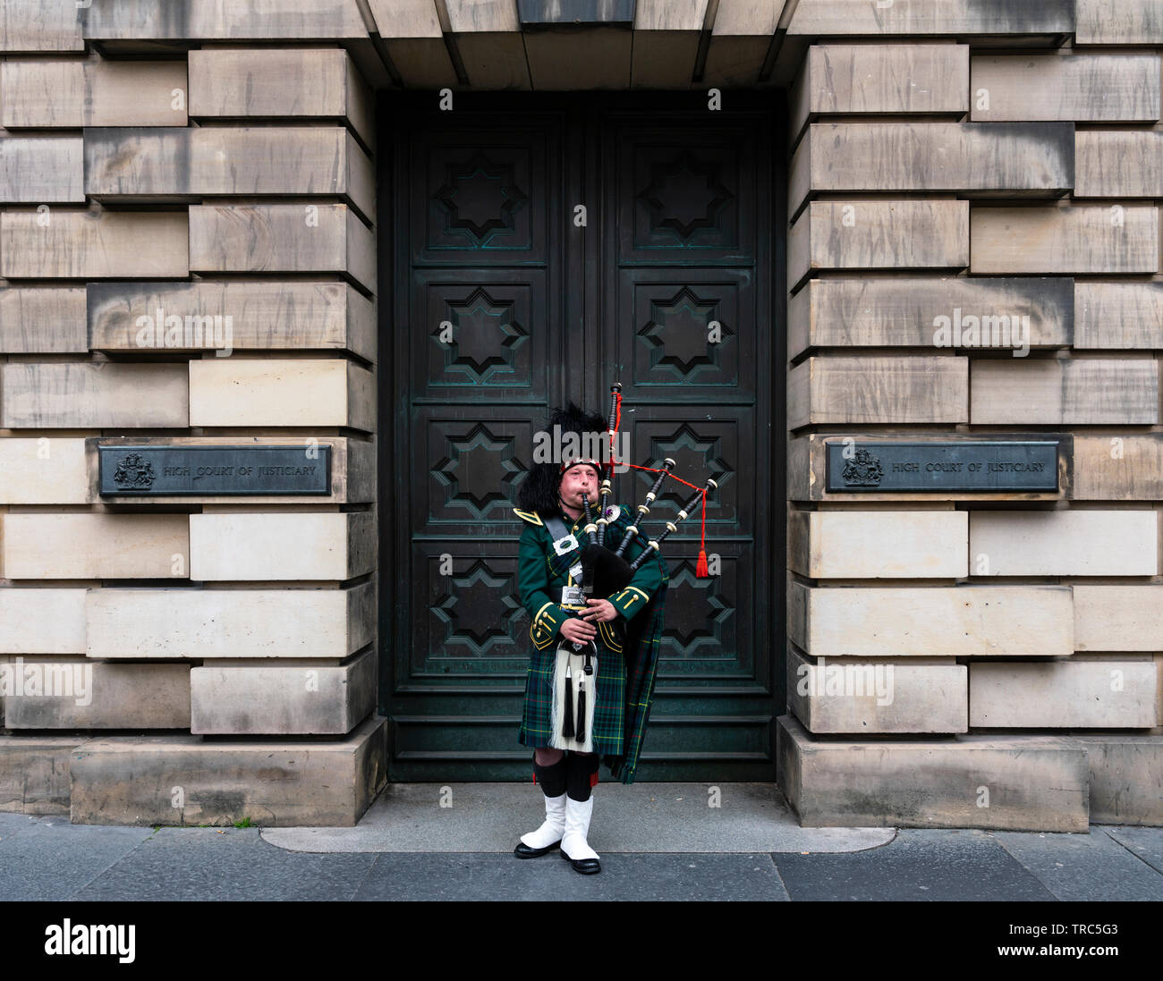 Scottish Piper spielt Dudelsack auf ausserhalb von Edinburgh Royal Mile High Court in der Altstadt von Edinburgh, Schottland, Großbritannien Stockfoto