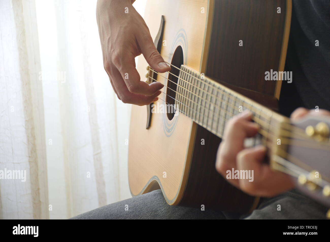 Mittelteil der junge Mann spielt akustische Gitarre Stockfoto