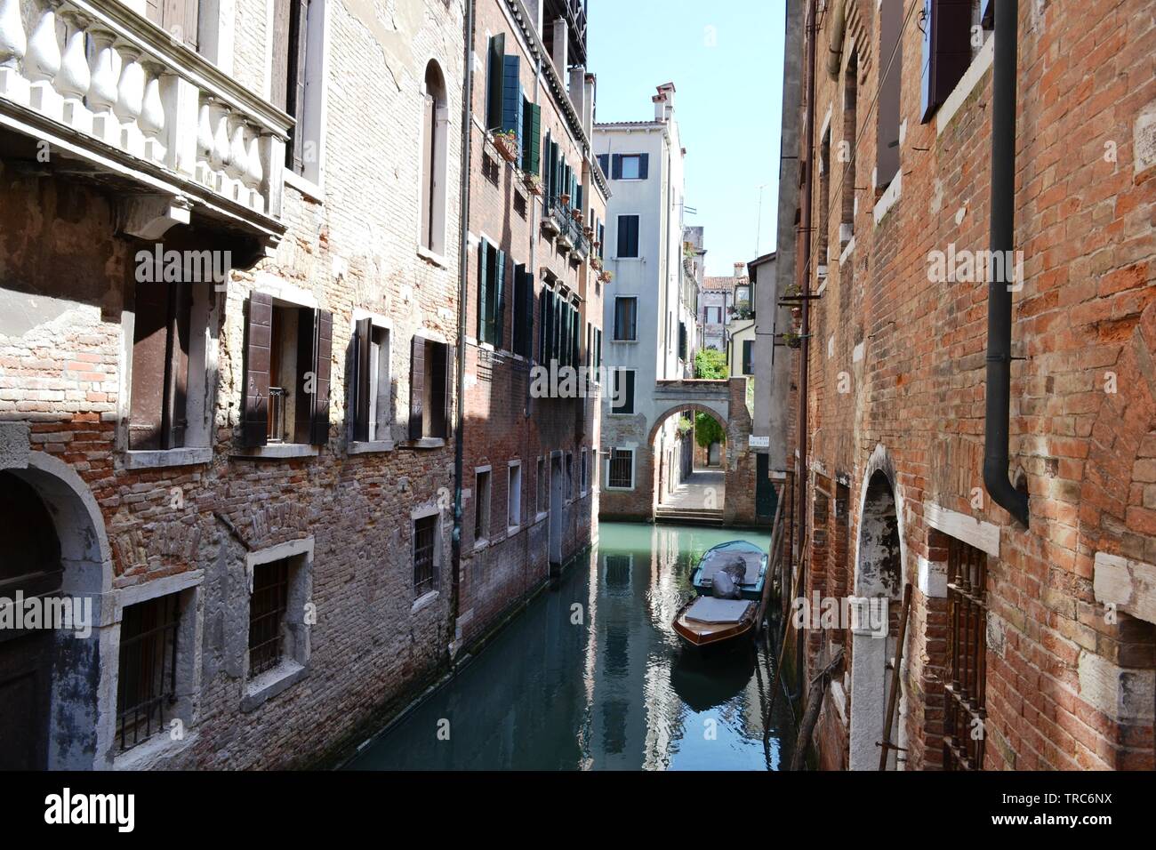 Schönen Panoramablick auf einem Kanal Straßen von Venedig mit Motorbooten an den Wänden der alten Häuser an einem sonnigen Frühlingstag verankert. Stockfoto