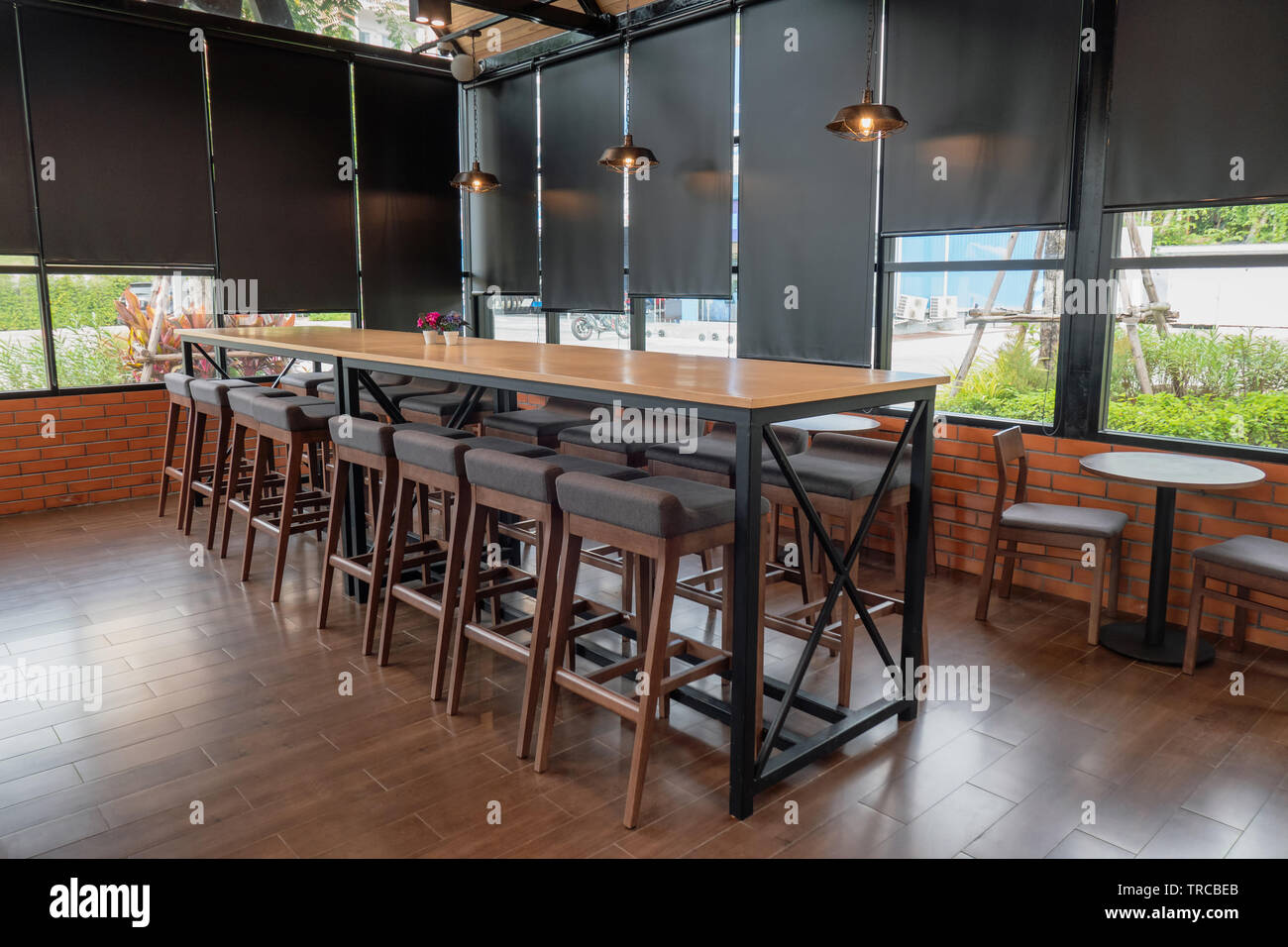 Holztisch mit Stühlen und Lampe Beleuchtung im Coffee Shop Stockfoto