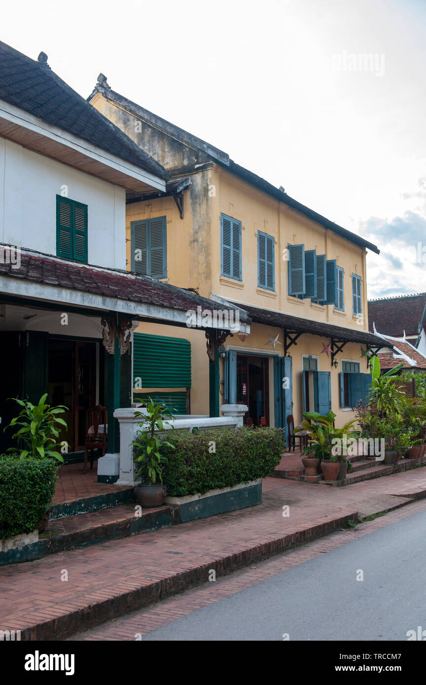Eine Straßenszene mit in der französischen Kolonialzeit erbauten Ladenhäusern im Zentrum von Luang Prabang, einer Stadt, die für ihre einzigartige Architektur zum Weltkulturerbe zählt. Stockfoto