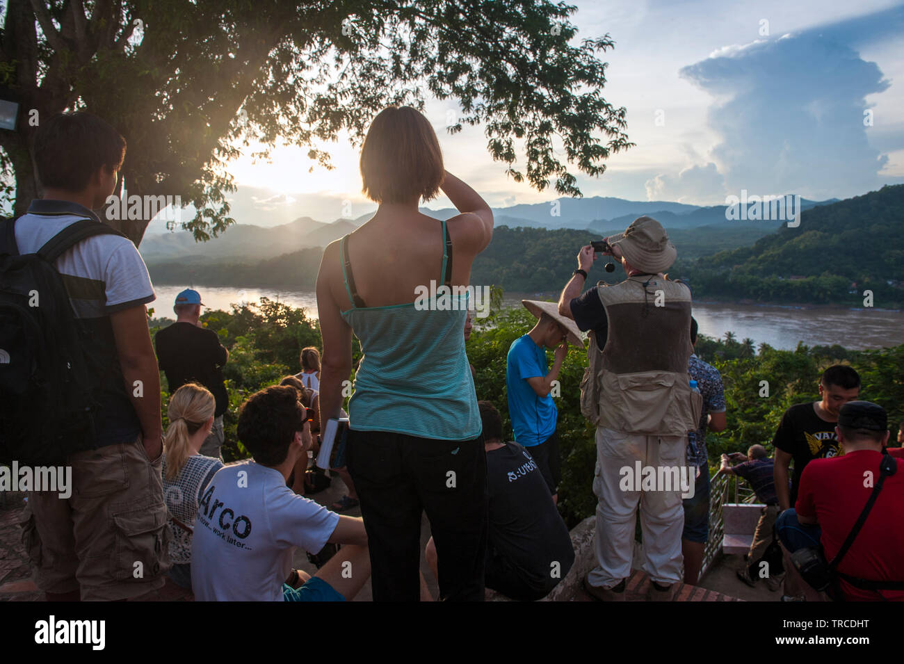 Touristen beobachten Sie den Sonnenuntergang am Mount Phousi, einem 100 m hohen Hügel im Zentrum der Altstadt von Luang Prabang, Lao PRD (Laos). Stockfoto