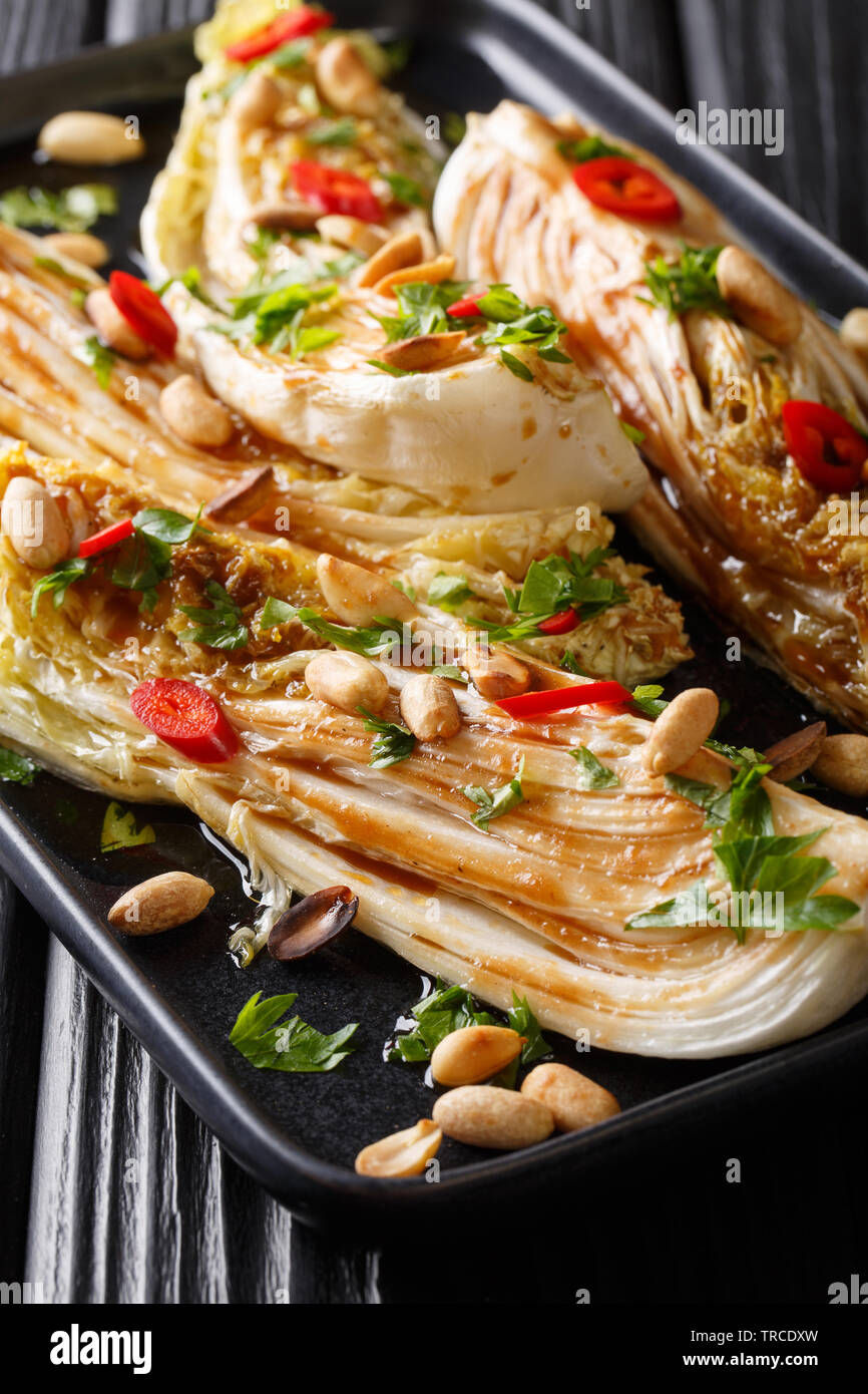 Gebackene Napa cabbage mit Sojasauce und Erdnüsse close-up auf einem Teller auf den Tisch. Vertikale Stockfoto