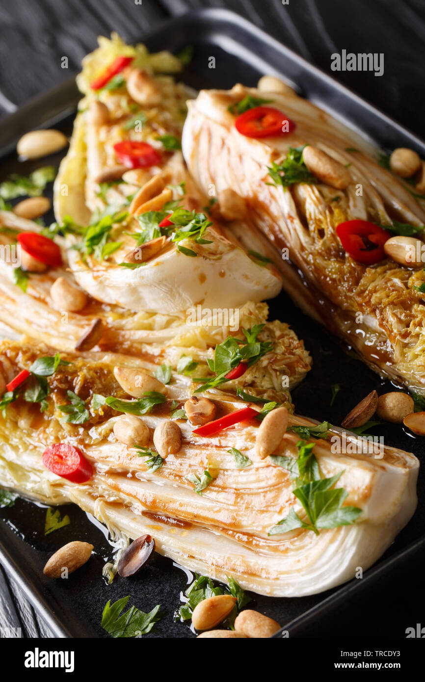 Gebratene Napa Kohl mit Tamari und Erdnüsse close-up auf einem Teller auf den Tisch. Vertikale Stockfoto