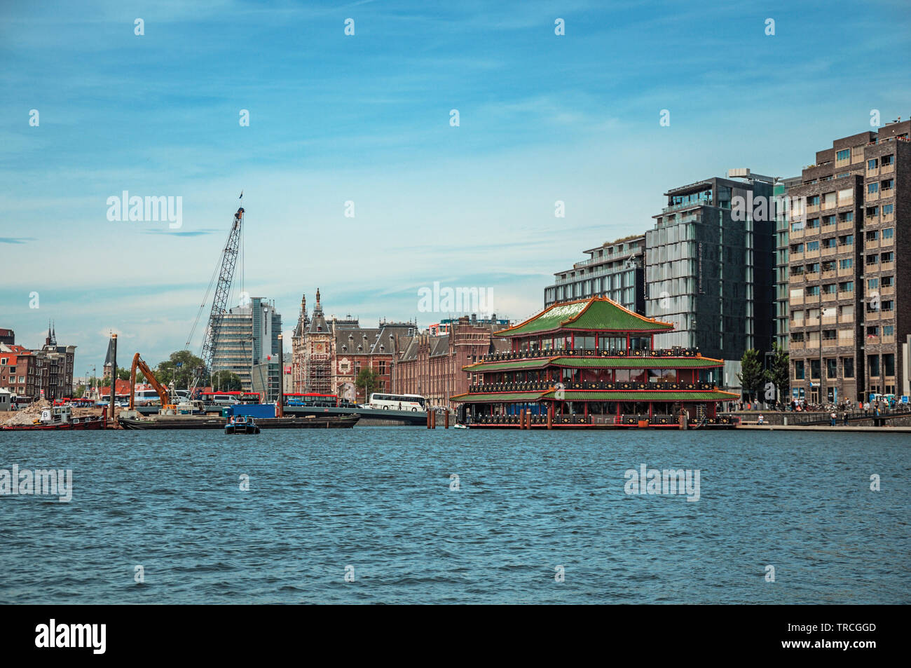Port, Kirchtürme und modernen Gebäuden auf Canal Bank und blauer Himmel in Amsterdam. Stadt mit riesigen kulturelle Aktivität, Kanäle und Brücken in den Niederlanden. Stockfoto