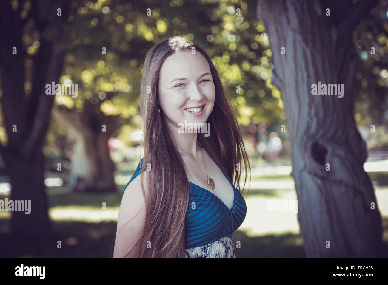 Kaukasische Frau glücklich läuft im Sommer/Frühling Stadt park Fröhlich und lächelnd in sundress um Bäume. Schöne frische multirassischen Kaukasischen. Caucasi Stockfoto
