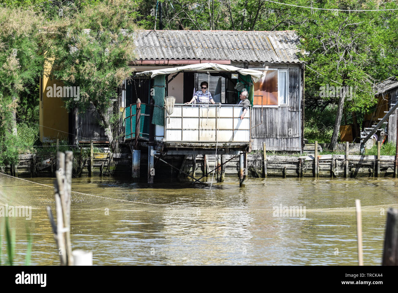 Angeln Häuser auf dem Fluss, Delta del Po, Comacchio, Emilia-Romagna, Italien. Juni 2019, Italien. Juni 2019 Stockfoto