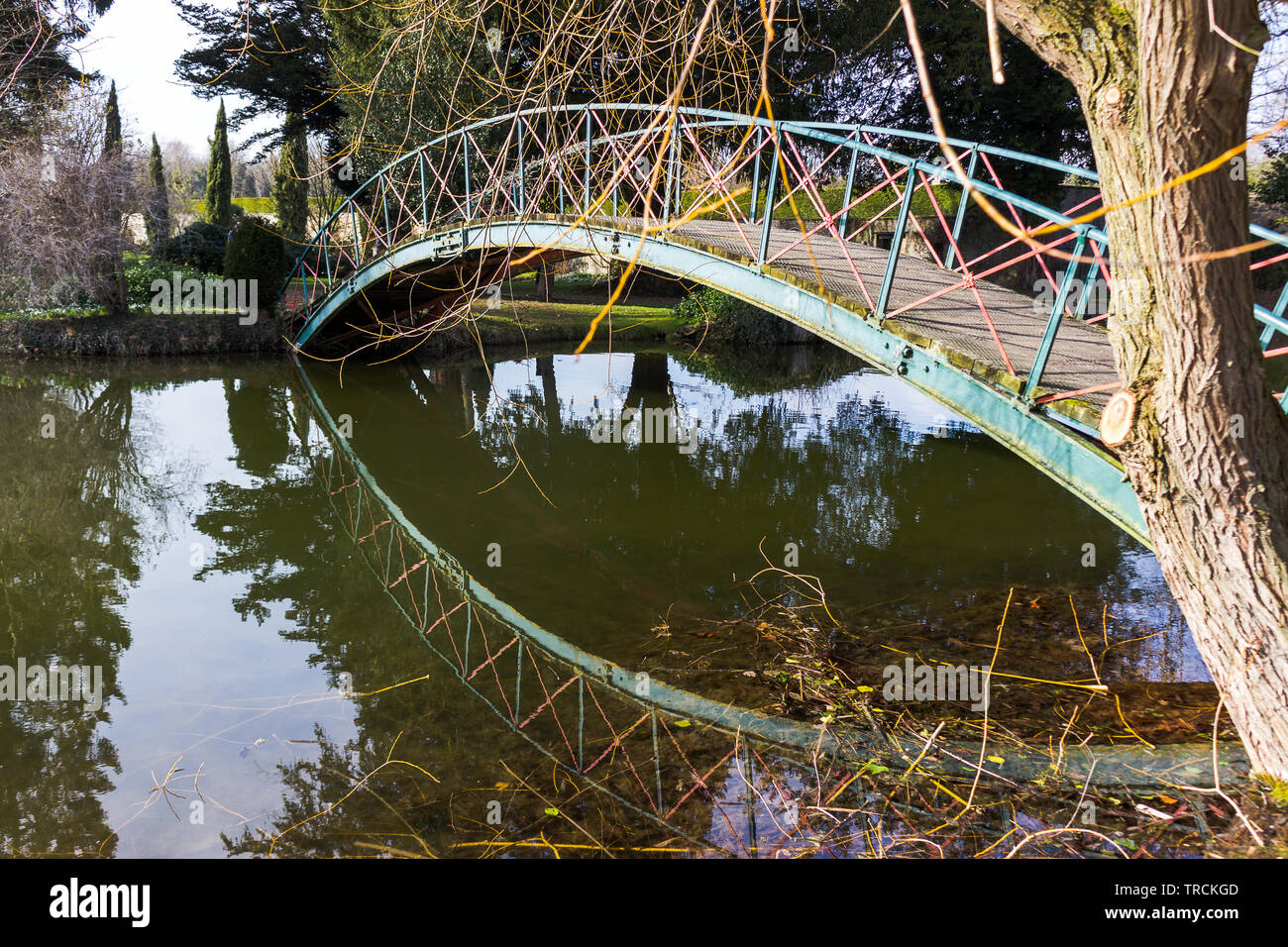 Fußgängerbrücke über den See in Chippenham Park, in dem die Reflexion in der immer noch Wasser. Stockfoto