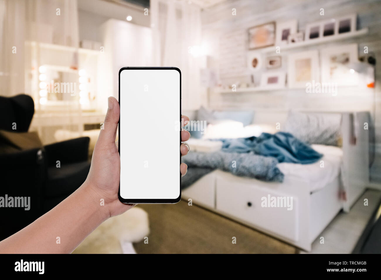 Mockup Bild von Hand mit modernen Handy mit leeren Kopie Raum desktop Bildschirm für ihre Werbung im Schlafzimmer Stockfoto
