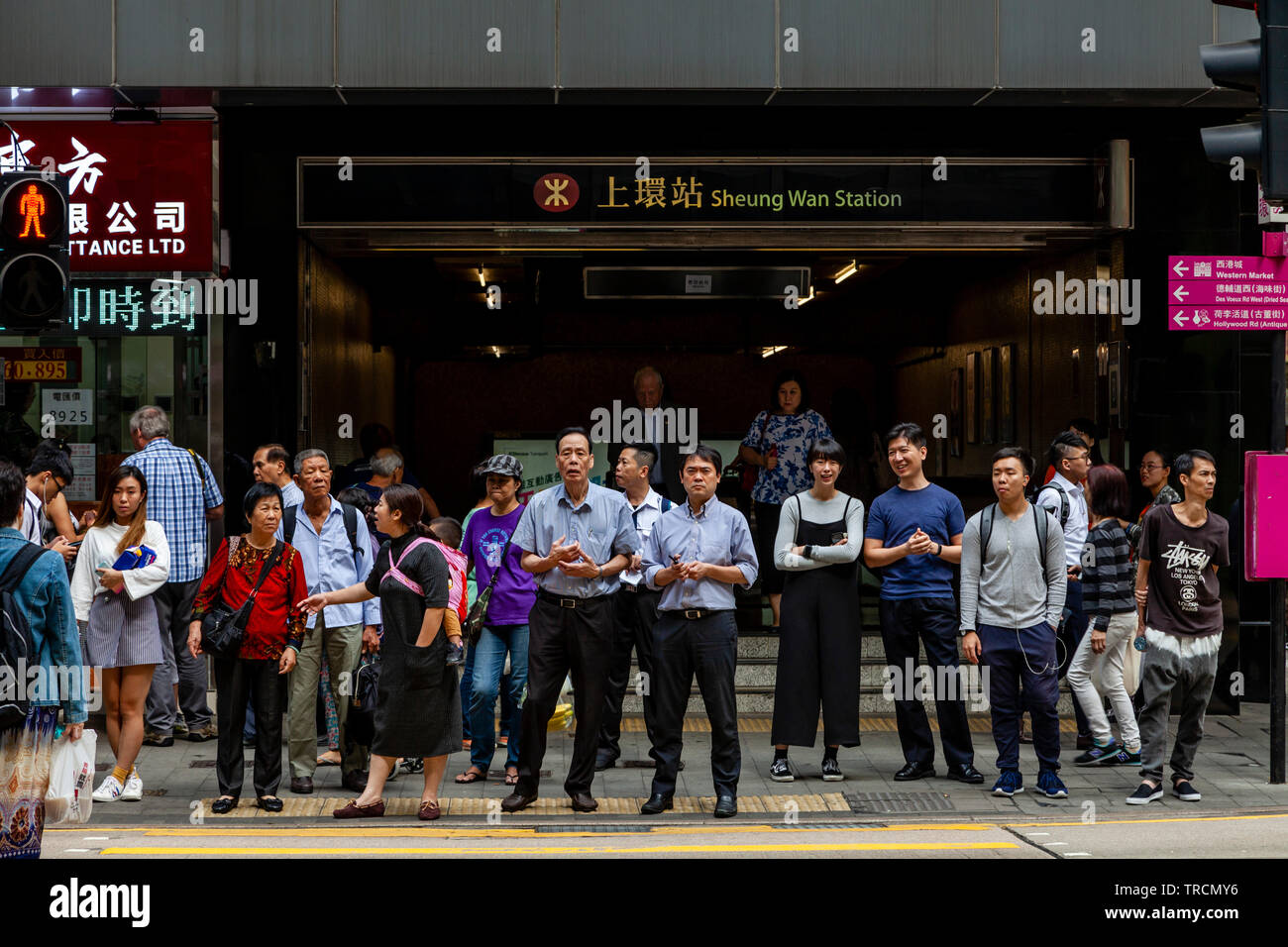 Eine große Gruppe von Menschen außerhalb der MTR-Haltestelle Sheung Wan, Hong Kong, China Stockfoto