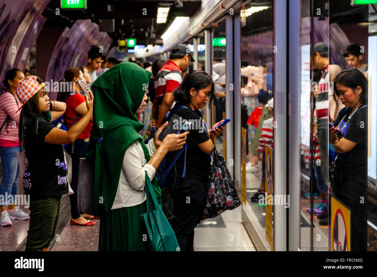 Leute für einen Zug an einer MTR-Station, Hong Kong, China warten Stockfoto