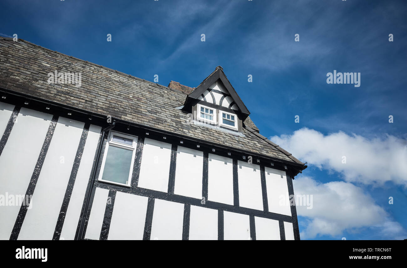 Holz- mock Tudor Gebäude mit kleinen Dachboden Satteldach Fenster eingerahmt. Stockfoto