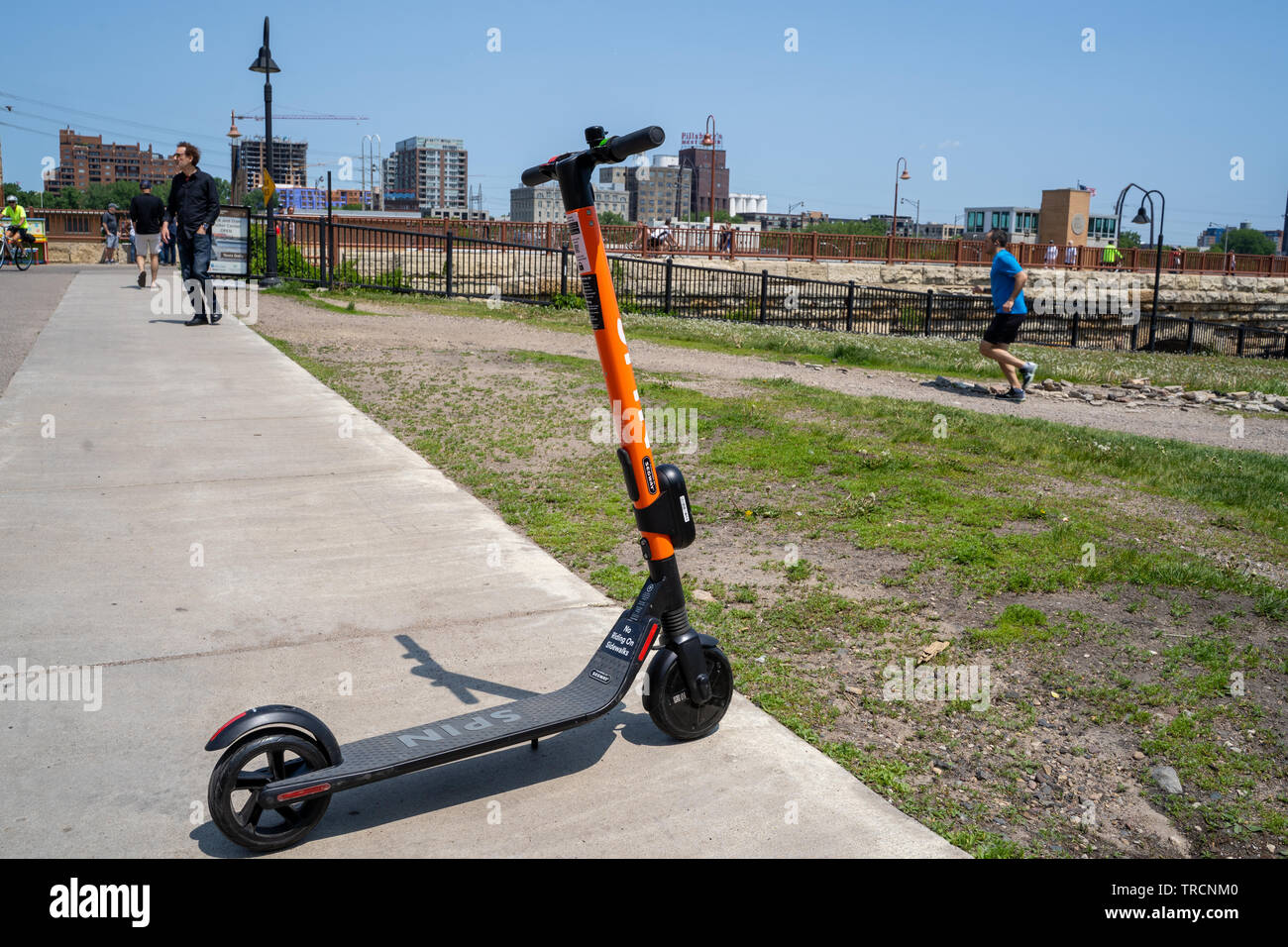 Minneapolis, MN - Juni 2, 2019: ein Spin Marke dockless, elektrische Gemeinschafts-Roller auf einem Bürgersteig in Mill Ruinen geparkt und wartet auf seine nächste Rider Stockfoto