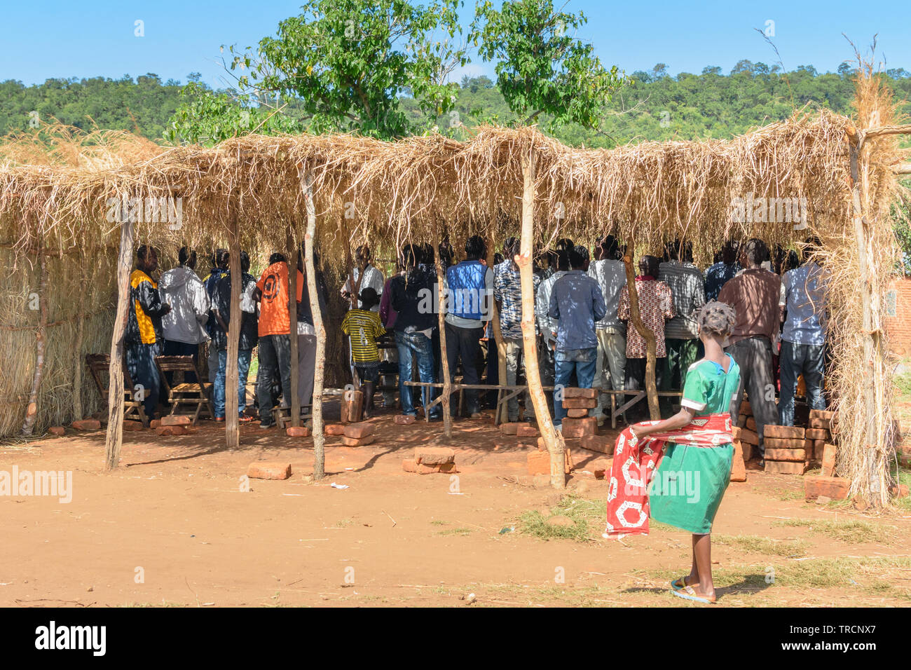 Männer sammeln in einem Gras Unterschlupf für eine Versammlung der Kirche in einem Dorf in Nsanje Malawi Stockfoto