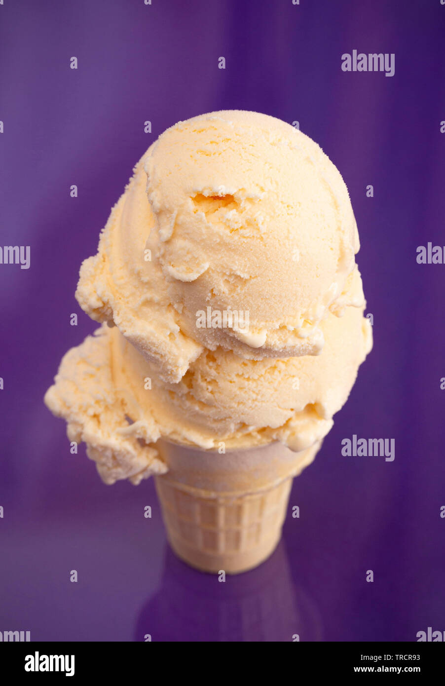 Double Scoop Vanille Eis auf einem violetten Hintergrund Stockfoto