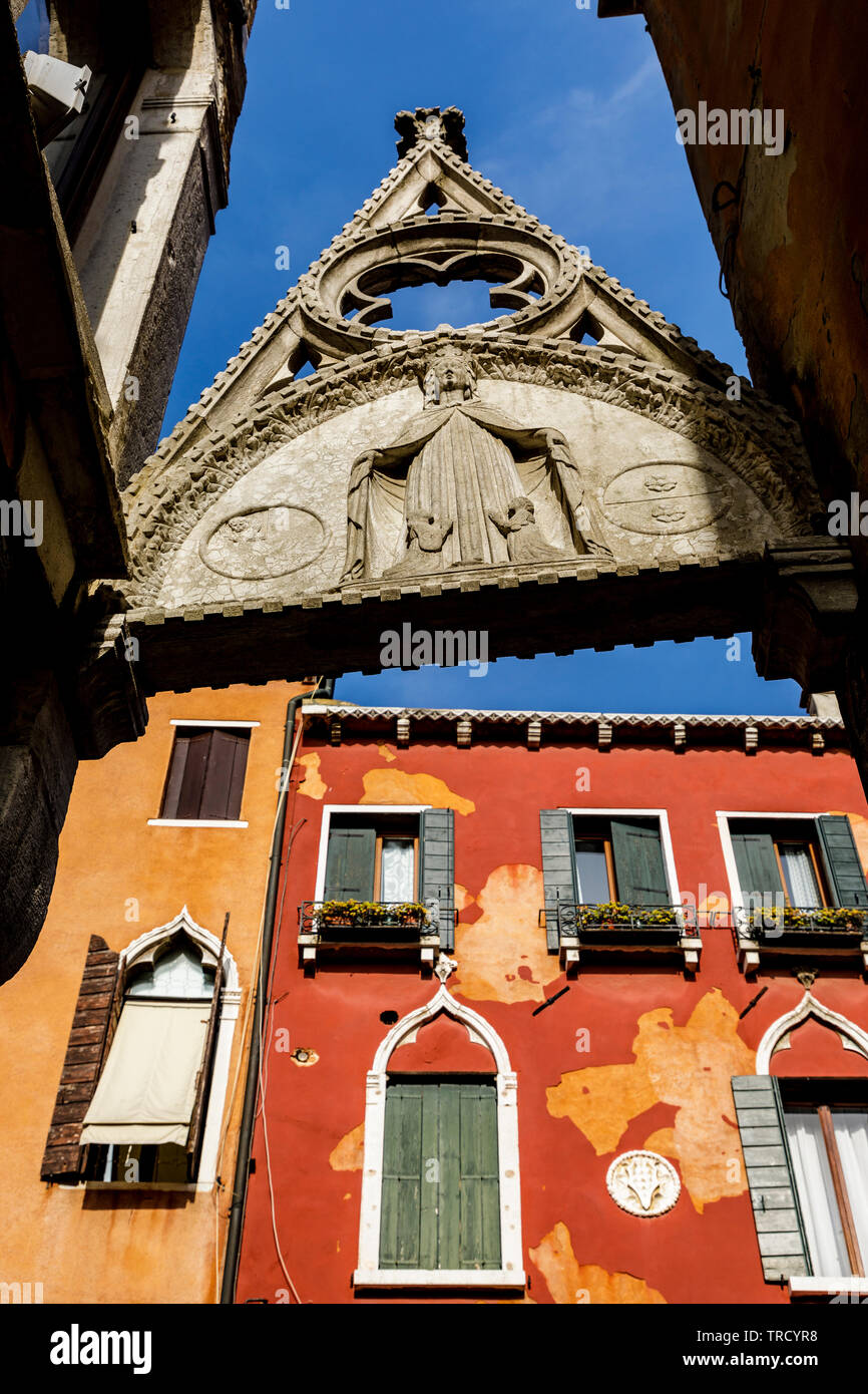 Ein Überbleibsel aus einer religiösen Struktur erstreckt sich über einen Gehweg in Venedig Italien. Stockfoto